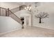 Bright living room with two-story ceiling, decorative wall art, staircase, and tile flooring at 4102 S 186Th Ave, Goodyear, AZ 85338