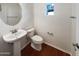 Clean bathroom with a pedestal sink, toilet, and wood floors at 1948 W Busoni Pl, Phoenix, AZ 85023