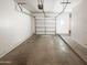 View of the spacious garage with an automatic door and concrete flooring, perfect for parking and storage at 1948 W Busoni Pl, Phoenix, AZ 85023