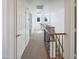 Upstairs hallway with white walls, neutral carpeting, wood and metal railing and natural light from windows at 1948 W Busoni Pl, Phoenix, AZ 85023