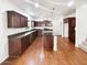 Spacious kitchen with dark wood cabinets, stainless steel appliances, and a large island for cooking at 1948 W Busoni Pl, Phoenix, AZ 85023