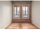 Empty bedroom featuring hardwood floors, exposed brick wall and two large windows at 114 W Adams St # 506, Phoenix, AZ 85003