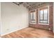 Empty bedroom with hardwood floors, exposed brick wall, and large windows at 114 W Adams St # 506, Phoenix, AZ 85003