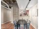 Modern dining space has a table and chairs, hardwood floors, concrete pillars, and kitchen access at 114 W Adams St # 506, Phoenix, AZ 85003