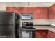 Kitchen with stainless steel appliances, granite countertops, and maroon colored wood cabinets at 114 W Adams St # 506, Phoenix, AZ 85003