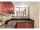 Kitchen featuring granite countertops and maroon colored wood cabinets at 114 W Adams St # 506, Phoenix, AZ 85003