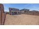 Wide view of the expansive, unfurnished backyard and home exterior at 17626 W Oregon Ave, Litchfield Park, AZ 85340