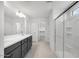 Bathroom showcasing double vanity with dark cabinets, a glass shower, and neutral wall color scheme at 17626 W Oregon Ave, Litchfield Park, AZ 85340