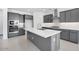 Stylish kitchen boasting gray cabinetry, stainless steel appliances, and a spacious island with a white countertop at 17626 W Oregon Ave, Litchfield Park, AZ 85340