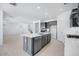 Spacious kitchen with gray cabinets, stainless steel appliances, and a large island with seating, open to living area at 17626 W Oregon Ave, Litchfield Park, AZ 85340