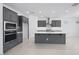 Modern kitchen featuring gray cabinets, stainless steel appliances, and a center island with a white countertop at 17626 W Oregon Ave, Litchfield Park, AZ 85340