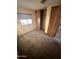 Comfortable bedroom with soft carpeting, a sunlit window, and a convenient closet for easy storage at 9427 E University Dr # 46, Mesa, AZ 85207