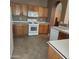 Bright kitchen features ample wood cabinets, white appliances, and tile flooring at 16147 W Central St, Surprise, AZ 85374