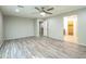 Bedroom with wood-look flooring, ceiling fan and ensuite bathroom at 18255 W Carlota Ln, Surprise, AZ 85387