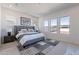 Bright bedroom featuring a plush bed, neutral decor, and multiple windows offering abundant natural light and backyard views at 23978 S 218Th Pl, Queen Creek, AZ 85142
