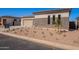 Charming home exterior with stone accents, well-kept yard, complemented by a spacious two-car garage at 23978 S 218Th Pl, Queen Creek, AZ 85142