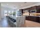 A stylish kitchen showcases a waterfall island with seating and stainless steel appliances at 23978 S 218Th Pl, Queen Creek, AZ 85142