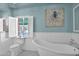 Elegant bathroom showcasing a freestanding tub, shuttered window, and light blue walls offering a spa-like experience at 1820 N 7Th Ave, Phoenix, AZ 85007
