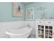 Bathroom with a standalone tub, decorative art and a white cabinet with shelves and drawers at 1820 N 7Th Ave, Phoenix, AZ 85007