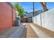 Long driveway between buildings with an AC unit on the side and a tall, wooden fence at 1820 N 7Th Ave, Phoenix, AZ 85007