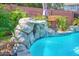 A delightful rock waterfall cascading into a refreshing pool amidst vibrant greenery and a privacy wall at 1820 N 7Th Ave, Phoenix, AZ 85007