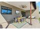Elegant covered patio featuring a dining table with a ceiling fan and outdoor television at 3125 N 86Th Pl, Scottsdale, AZ 85251