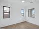 Bright bedroom with wood-look tile flooring, three windows, and ample natural light, creating an airy ambiance at 3624 N 59Th St, Mesa, AZ 85215
