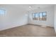 Spacious bedroom with wood-look tile flooring, three windows, and a ceiling fan for optimal comfort at 3624 N 59Th St, Mesa, AZ 85215