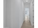 Well-lit hallway with wood-look tile flooring and white walls, leading to various rooms in the home at 3624 N 59Th St, Mesa, AZ 85215