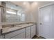 Bathroom with double sink vanity, granite countertop, large mirror, and white cabinets at 40000 W Bravo Dr, Maricopa, AZ 85138