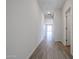 Bright hallway with stylish wood-look tile flooring leading to an open-concept living space at 40000 W Bravo Dr, Maricopa, AZ 85138