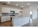 Bright kitchen featuring an island with a granite countertop, stainless steel appliances, and modern cabinets at 40000 W Bravo Dr, Maricopa, AZ 85138
