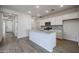 Bright kitchen featuring an island with a granite countertop, stainless steel appliances, and modern cabinets at 40000 W Bravo Dr, Maricopa, AZ 85138