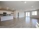Open concept living room featuring tile flooring, bright light, and an open kitchen at 40000 W Bravo Dr, Maricopa, AZ 85138