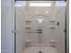 Bright shower with glass door, small window and built in shelving for storage at 40000 W Bravo Dr, Maricopa, AZ 85138