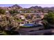 Community pool and lounge area with surrounding neighborhood, lush landscaping, and scenic mountain backdrop at 2626 E Arizona Biltmore Cir # 40, Phoenix, AZ 85016