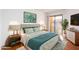 Comfortable bedroom with a light green bedspread and access to a balcony at 11640 N 51St Ave # 250, Glendale, AZ 85304