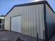 Metal garage building with large roll-up door and concrete floor at 394 N Pinyon Dr, Apache Junction, AZ 85120