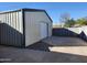 Tan metal storage shed with roll-up garage door at 394 N Pinyon Dr, Apache Junction, AZ 85120