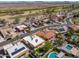 Stunning aerial view of a desert neighborhood with manicured lawns, pools, and solar panels at 923 W Crooked Stick Dr, Casa Grande, AZ 85122