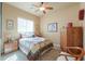 Cozy bedroom featuring a ceiling fan and a sunlit window with a patterned bedspread at 923 W Crooked Stick Dr, Casa Grande, AZ 85122