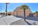 Beige stucco home with a two car garage, desert landscaping and palm trees at 923 W Crooked Stick Dr, Casa Grande, AZ 85122