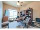 Well-lit home office with built-in bookcase, desk, and a ceiling fan at 923 W Crooked Stick Dr, Casa Grande, AZ 85122