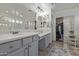 Bright bathroom featuring dual sinks, a vanity area, large mirrors, and walk-in closet at 4446 W Hower Rd, Phoenix, AZ 85086