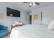 Bright bedroom with a TV, accent chair, and large closet with sliding doors at 4446 W Hower Rd, Phoenix, AZ 85086