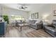 Bright living room with a large gray sectional, modern ceiling fan, and wood-look tile flooring at 4446 W Hower Rd, Phoenix, AZ 85086