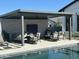 Covered patio with seating area, adjacent to a refreshing pool at 20475 E Indiana Ave, Queen Creek, AZ 85142