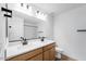 Bathroom featuring double sinks, wood cabinets, and modern fixtures at 25238 N 172Nd Ln, Surprise, AZ 85378