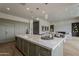 Open concept kitchen with an oversized island, pendant lighting, stainless appliances and light green cabinetry at 37200 N Cave Creek Rd # 1023, Scottsdale, AZ 85262