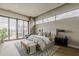 Spacious main bedroom with a stone accent wall, wide windows and sliding glass doors leading to the pool area at 37200 N Cave Creek Rd # 1023, Scottsdale, AZ 85262